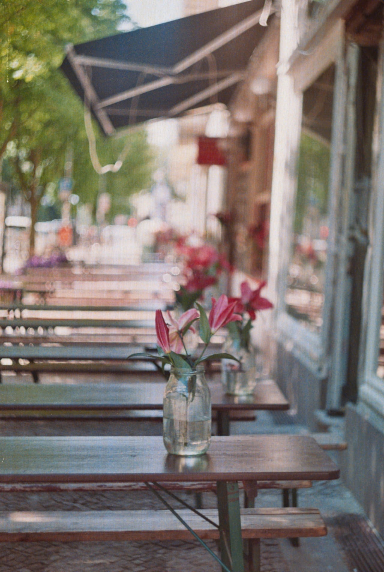 A pavement café at morning, fresh lilies in jars on the front tables